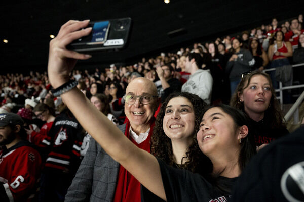 Two Northeastern students taking a selfie with the university president 